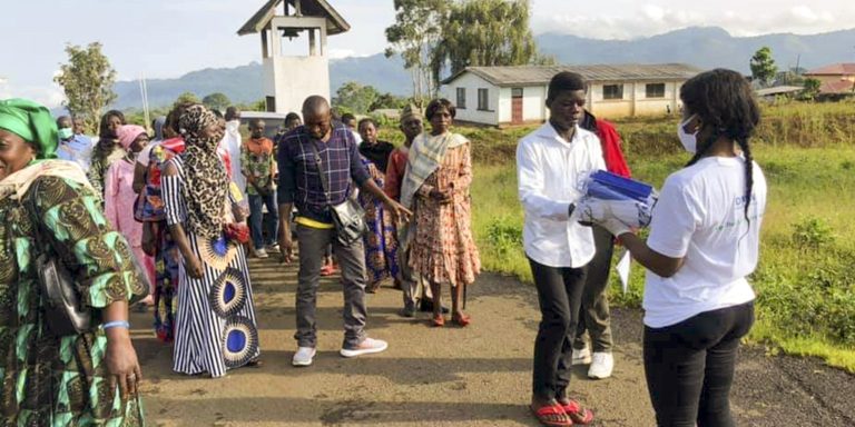 Distribution of face mask in front of the Catholic Church Bangem