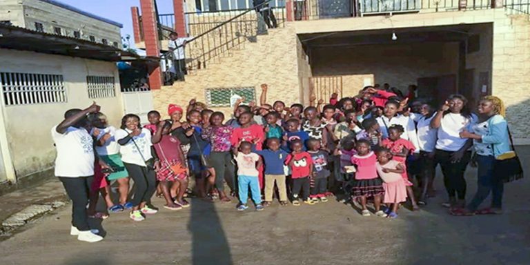 Participants and organisers posing for picture in front of the catholic church Mile 16 at the end of the workshop