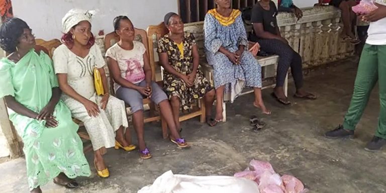 Women sitting inline to receive their agricultural items