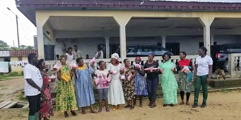 Beneficiaries after receiving the seeds and agricultural items posing for pictures